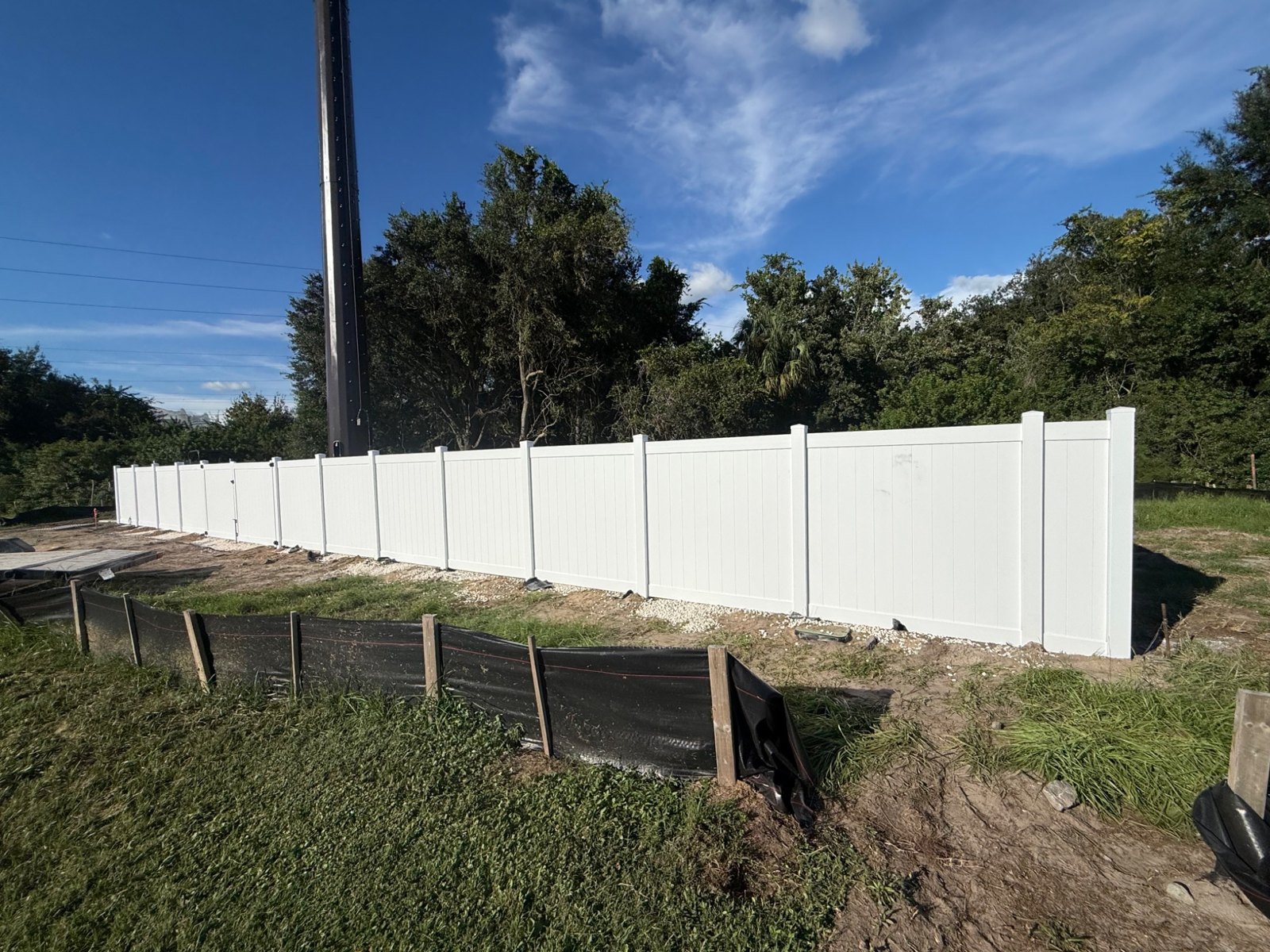 White vinyl privacy fence along a property edge