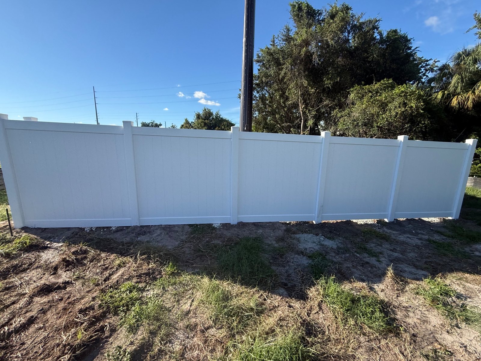 White vinyl privacy fence in sunlight