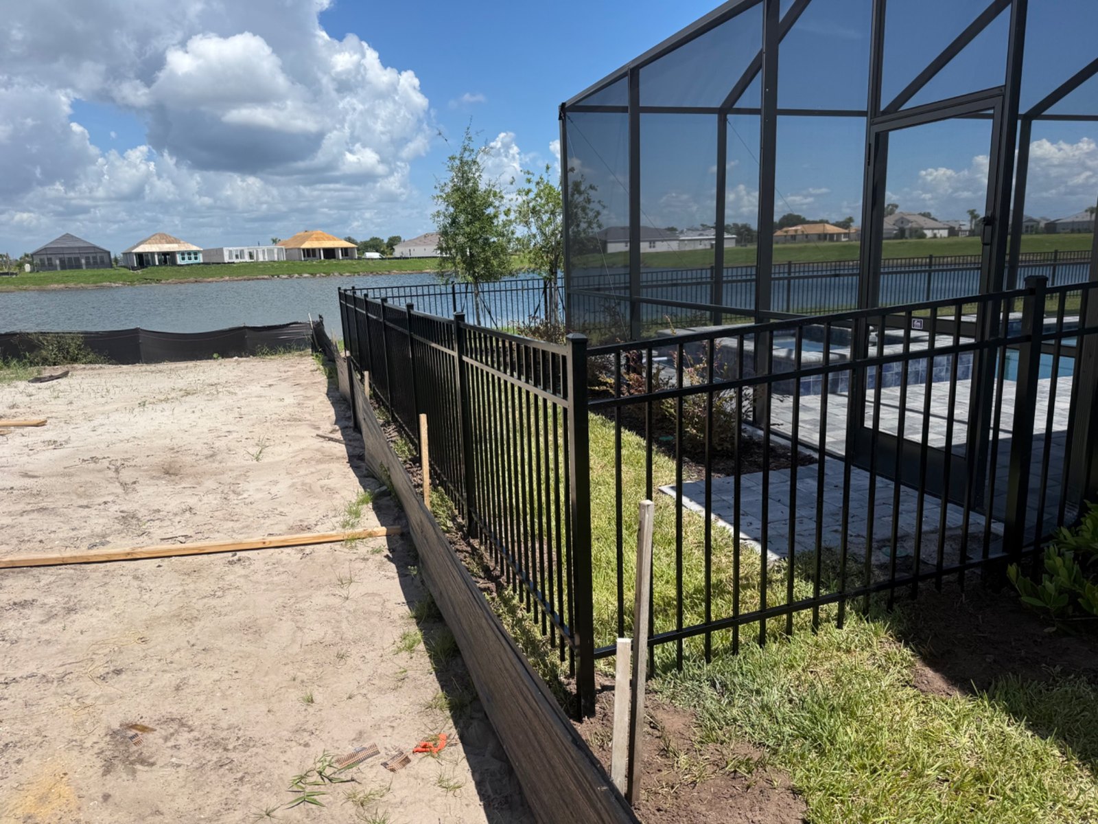 Black aluminum fence along a waterfront lawn
