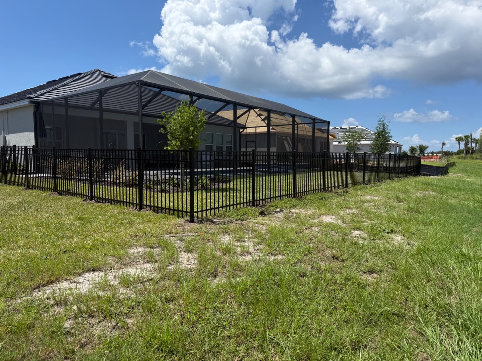 Wide view of black aluminum fencing around a backyard