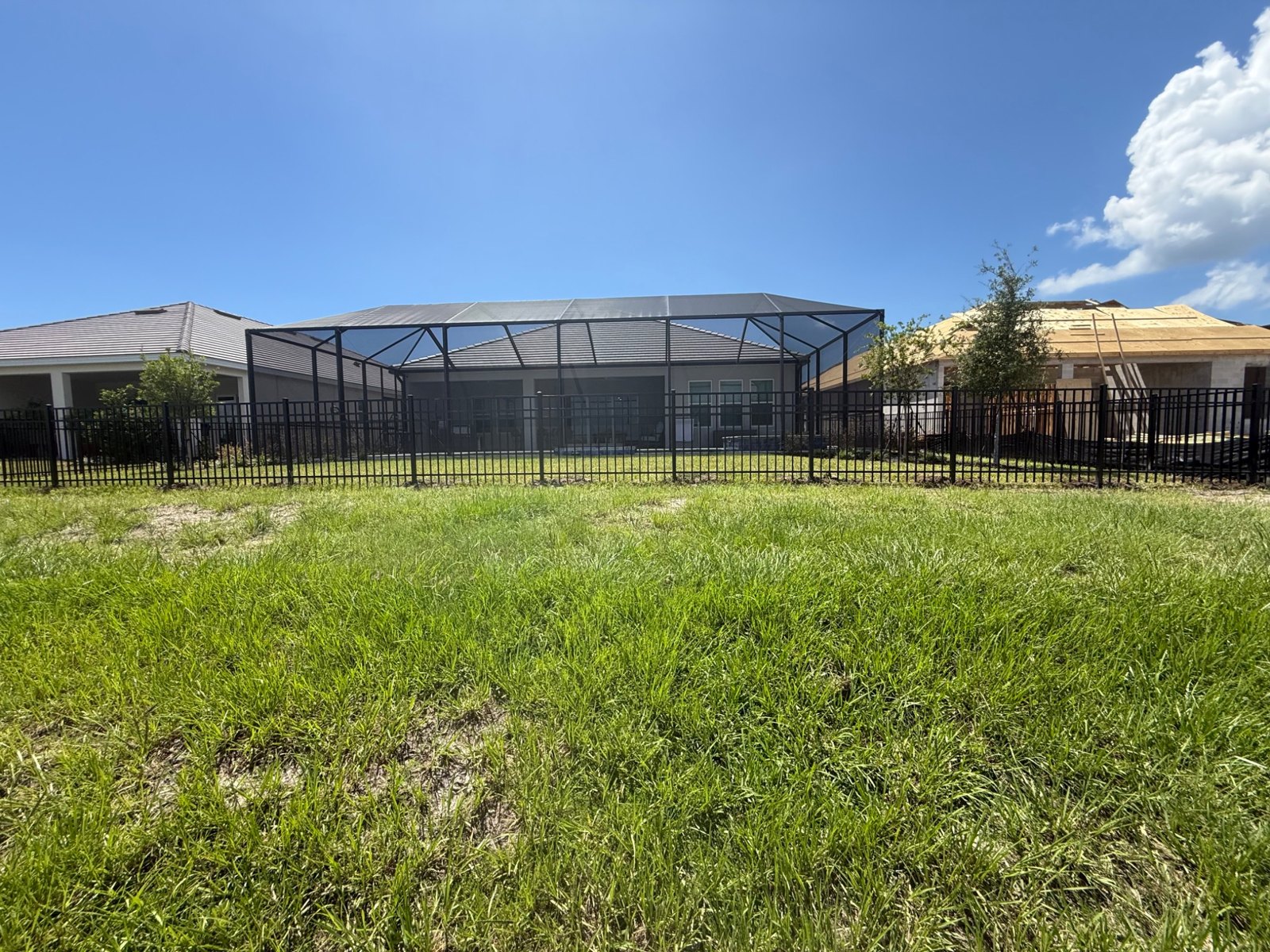 Aluminum fence across a green lawn