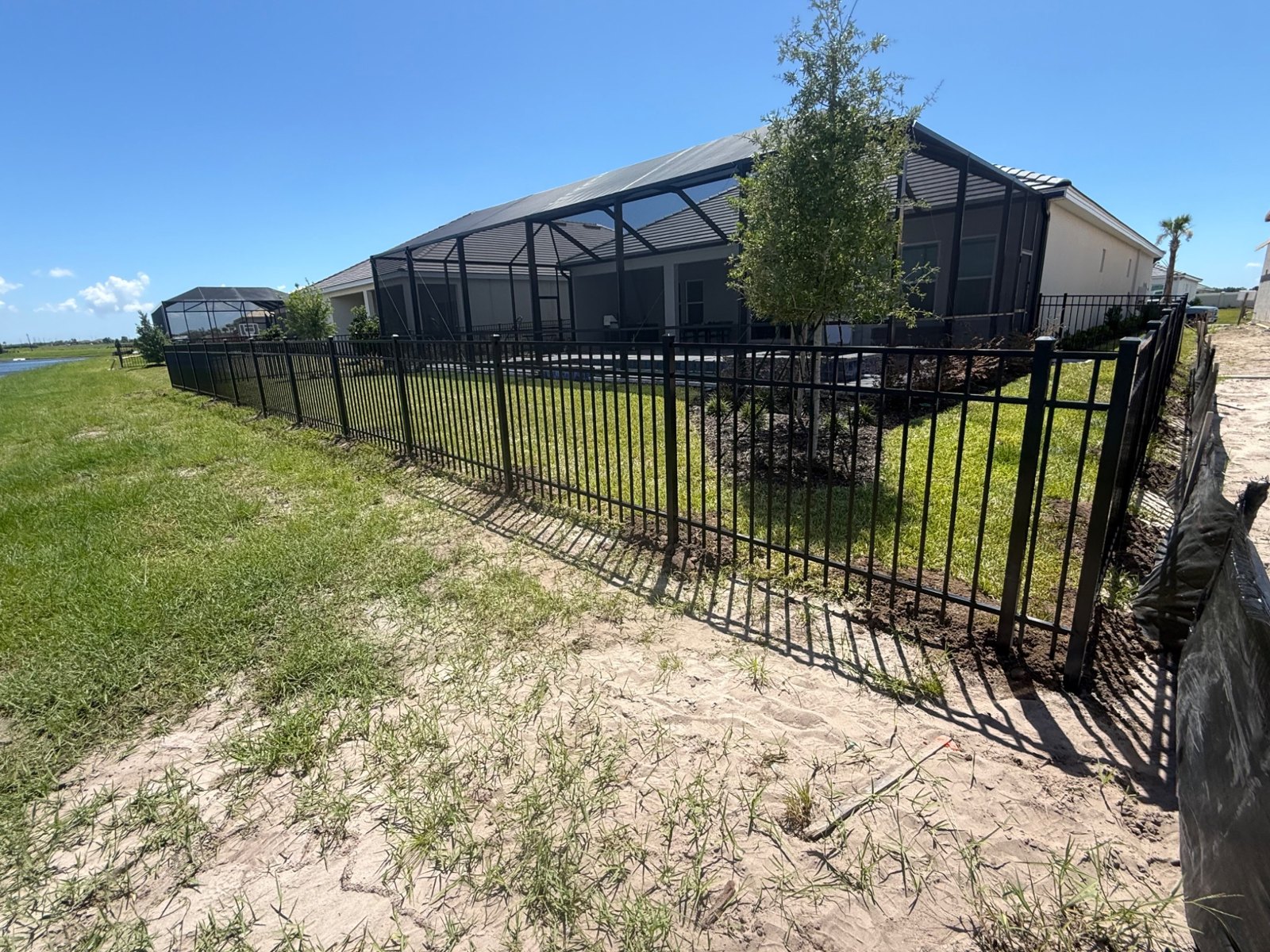 Aluminum fence line and gate beside a patio