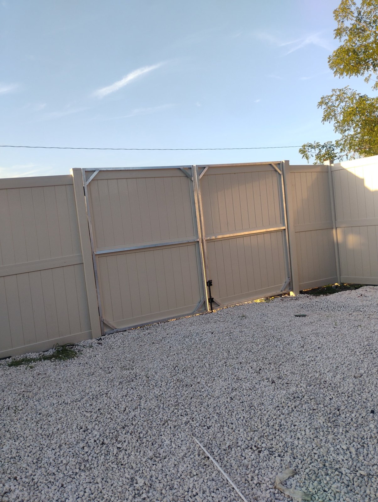 Tan vinyl privacy fencing — view 1